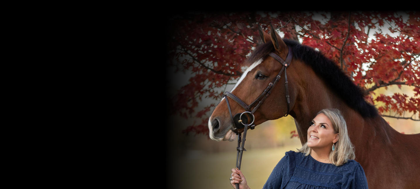 Woman standing next to a horse with a scenic background